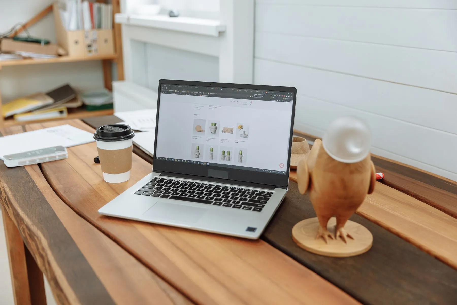 A laptop on a wooden desk showing a business website
