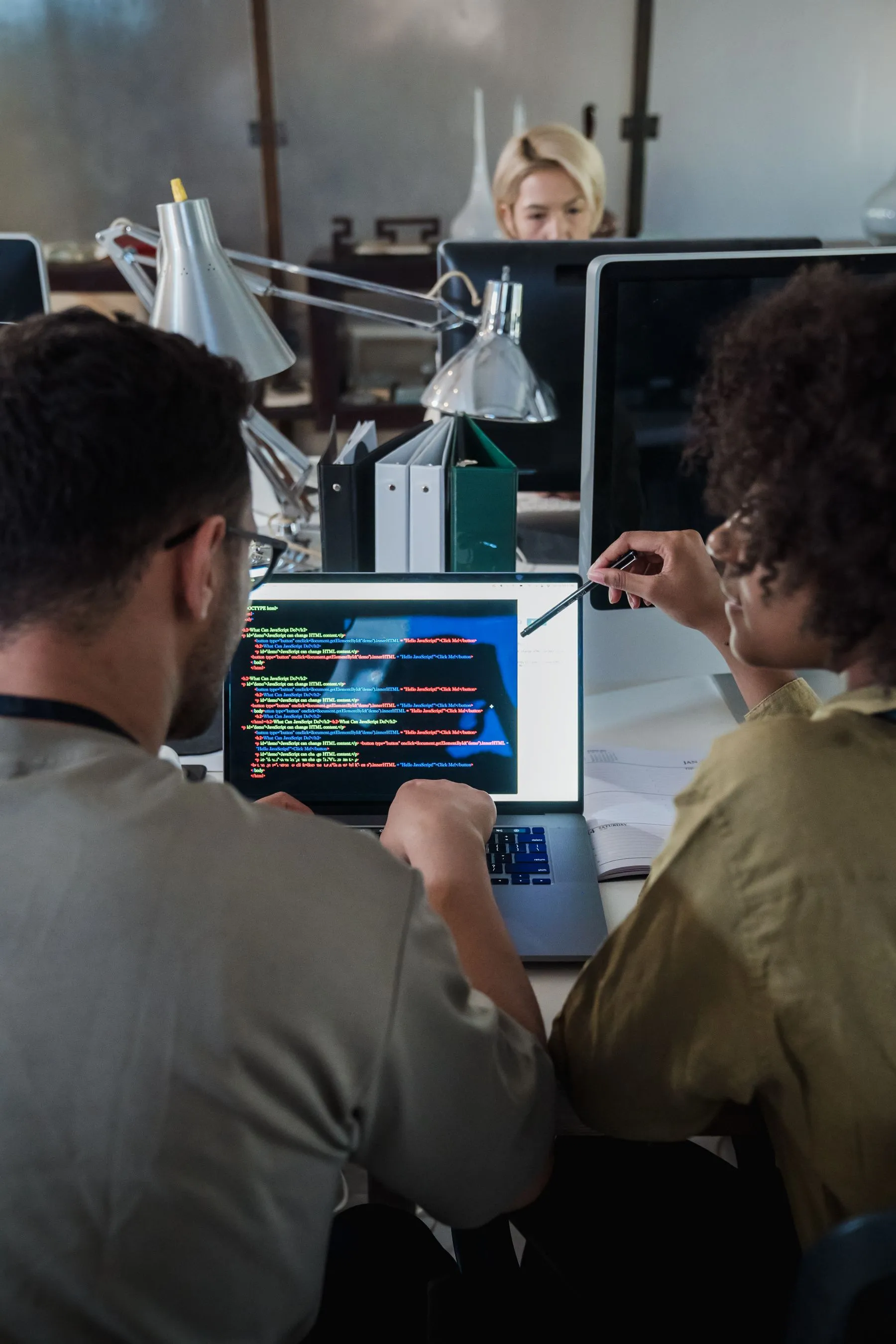 Two developers reviewing code on a laptop